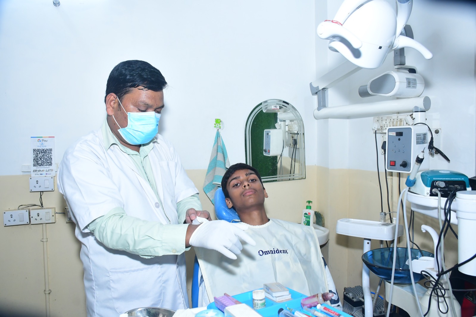 Receptionist smiling at a woman standing at the First Smile Dental Clinic front desk.
