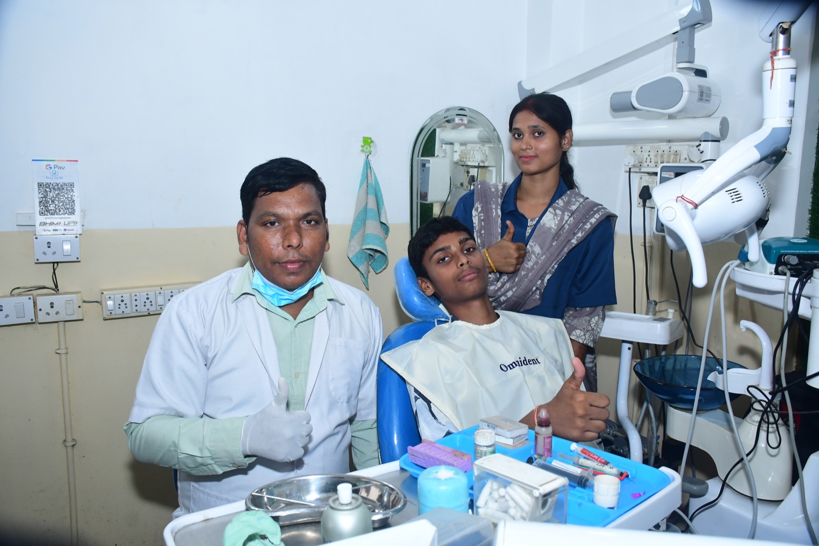 Dentist in blue gloves and mask working on a patient's teeth in a dental office.